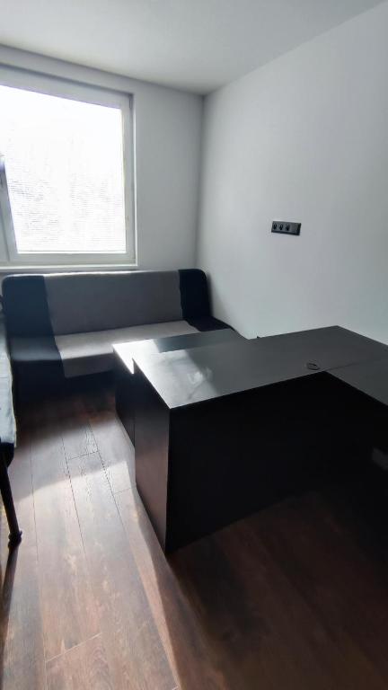 a room with a bench in front of a window at Centrum apartman s parkovaním in Trenčín