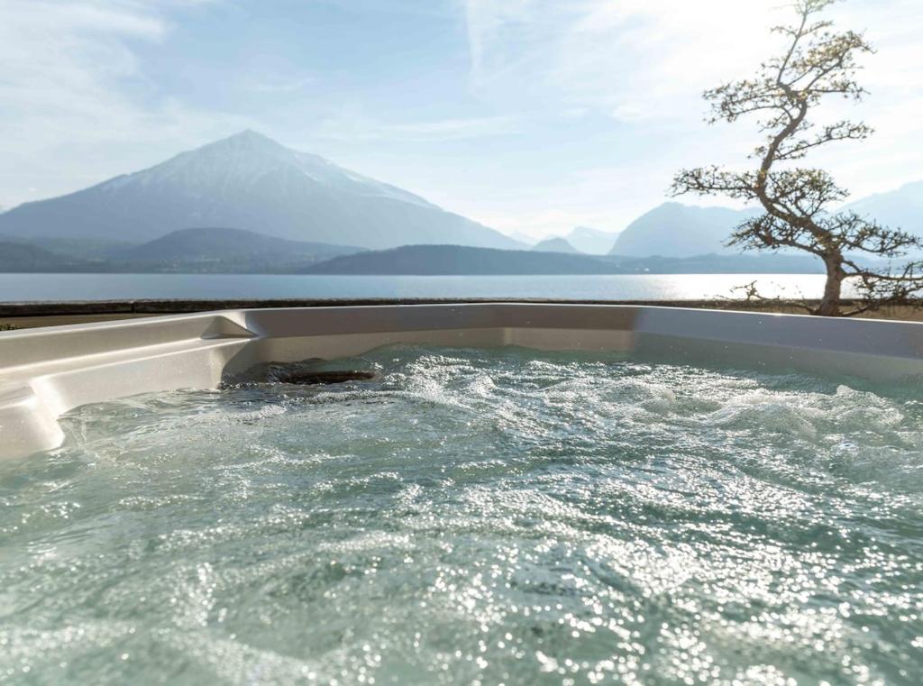 a jacuzzi tub with a view of a mountain at Nido sull`Aqua Chalet with Whirlpool in Sigriswil