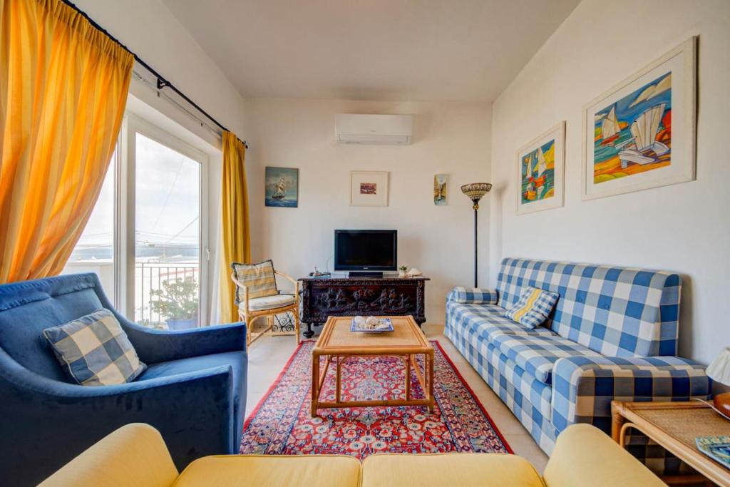 a living room with two couches and a table at Davina House - Terrace & Garden - Sea Views in St. Paul's Bay