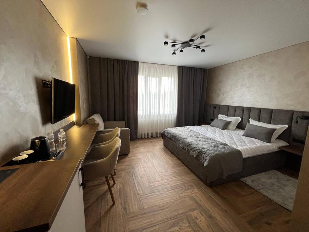 a hotel room with a bed and a desk at Amaro Hotel Uman in Uman