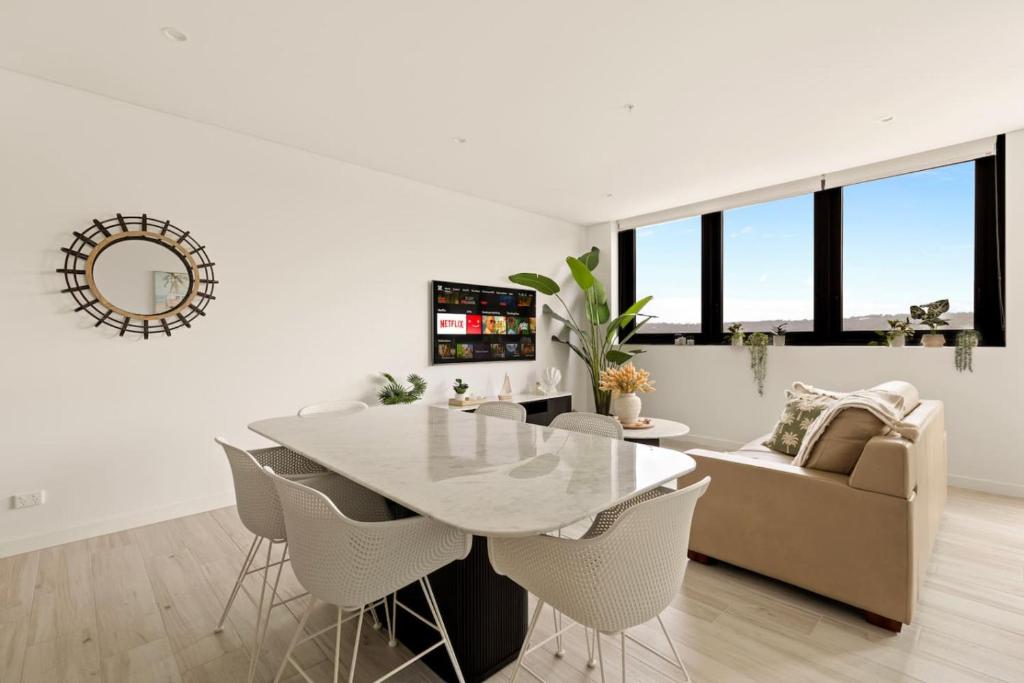 a white dining room with a table and chairs at 2BDR Luxury Apartment Panoramic Views in Gosford