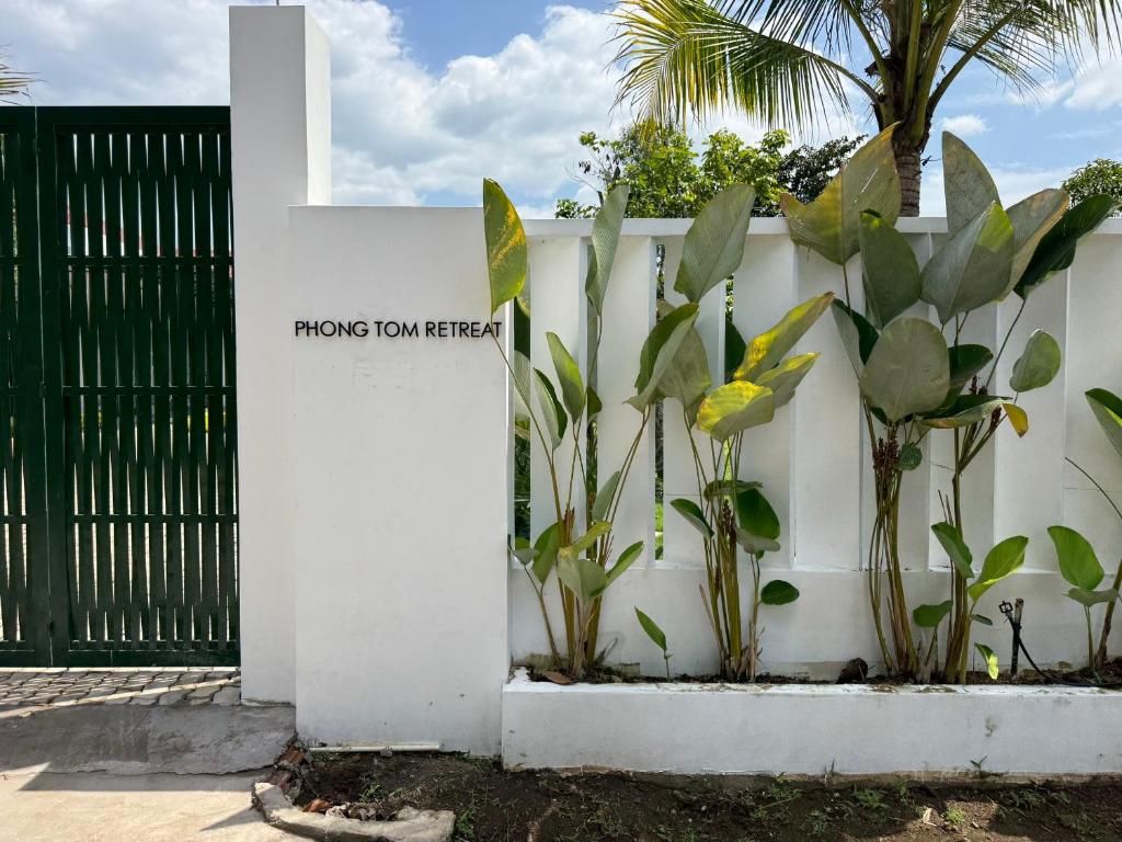 a white fence with plants and a cross on it at Phong Tom Retreat - Pet friendly location in Long Khanh
