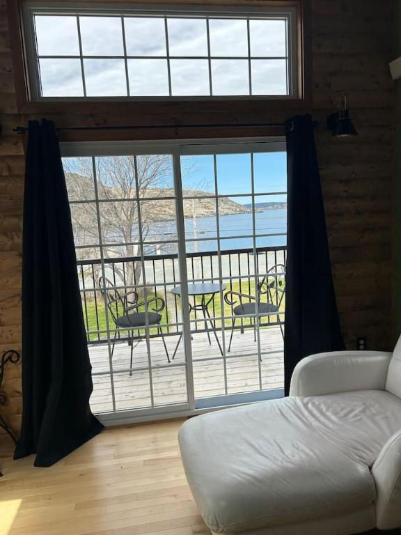 a living room with a large window with a view of a patio at Cupids Guest House and SheShed in Brigus