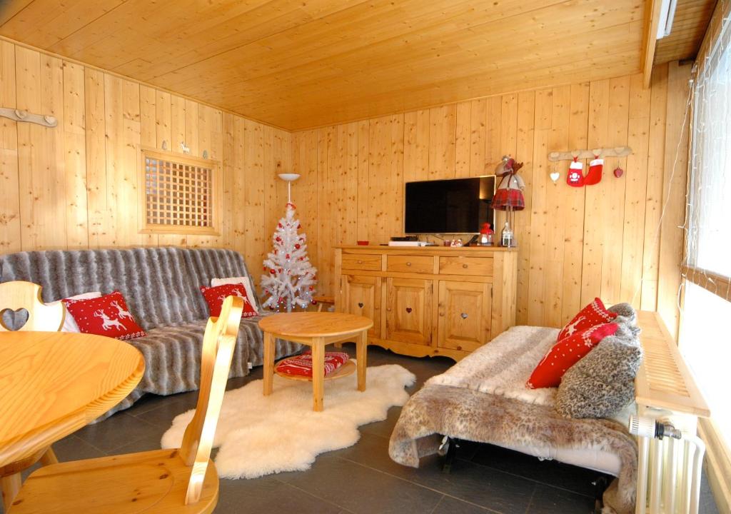 a living room with a couch and a christmas tree at Apartment Anna in Courchevel