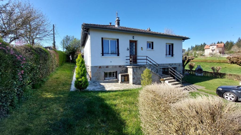 a white house with a car parked in front of it at Gîte 6 pers jardin clos proche plage et lac Cantal in Lacapelle-Viescamp