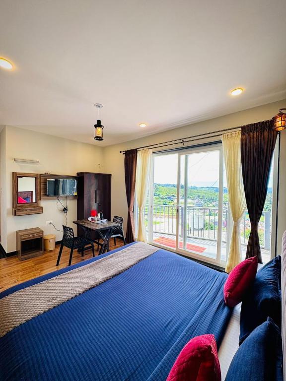a bedroom with a large bed and a large window at Everfreshhighviewcottage in Ooty