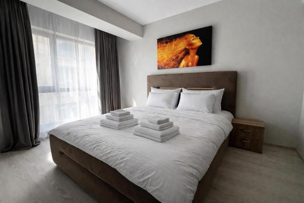 a bedroom with a large bed with towels on it at Elaris Aparthotel 6 SELF CHECK-IN #Otopeni #Airport #Therme #Bucharest in Otopeni