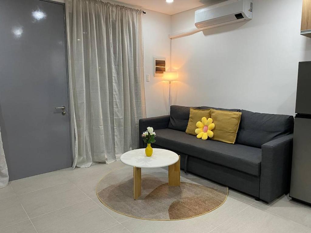 a living room with a couch and a table at Cozy Haven Batulao in Calo