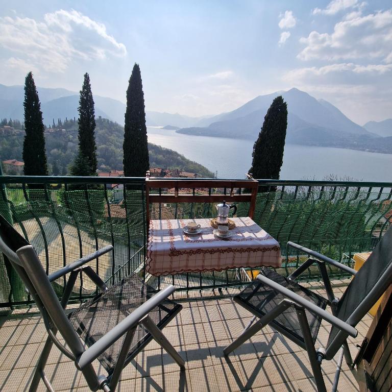 a table and chairs on a balcony with a view of a lake at LA PERLA DEL CENTRO LAGO DI COMO in Perledo