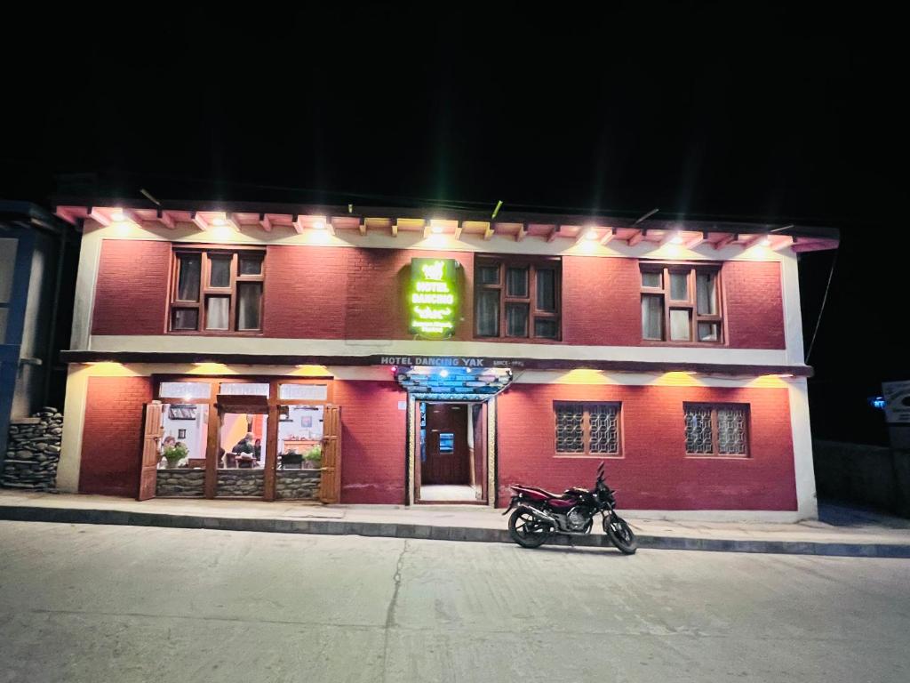 a red building with a motorcycle parked in front of it at Hotel Dancing Yak in Jomsom