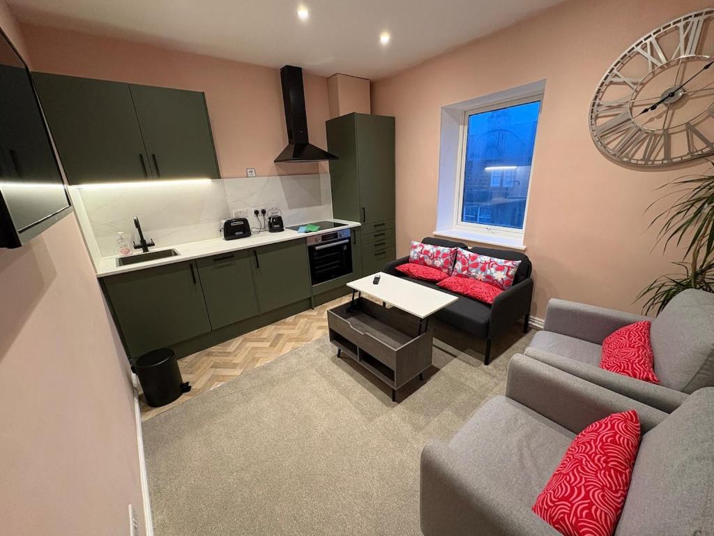 a living room with a couch and a kitchen at Bright Harrogate flat 2 beds great location in Harrogate