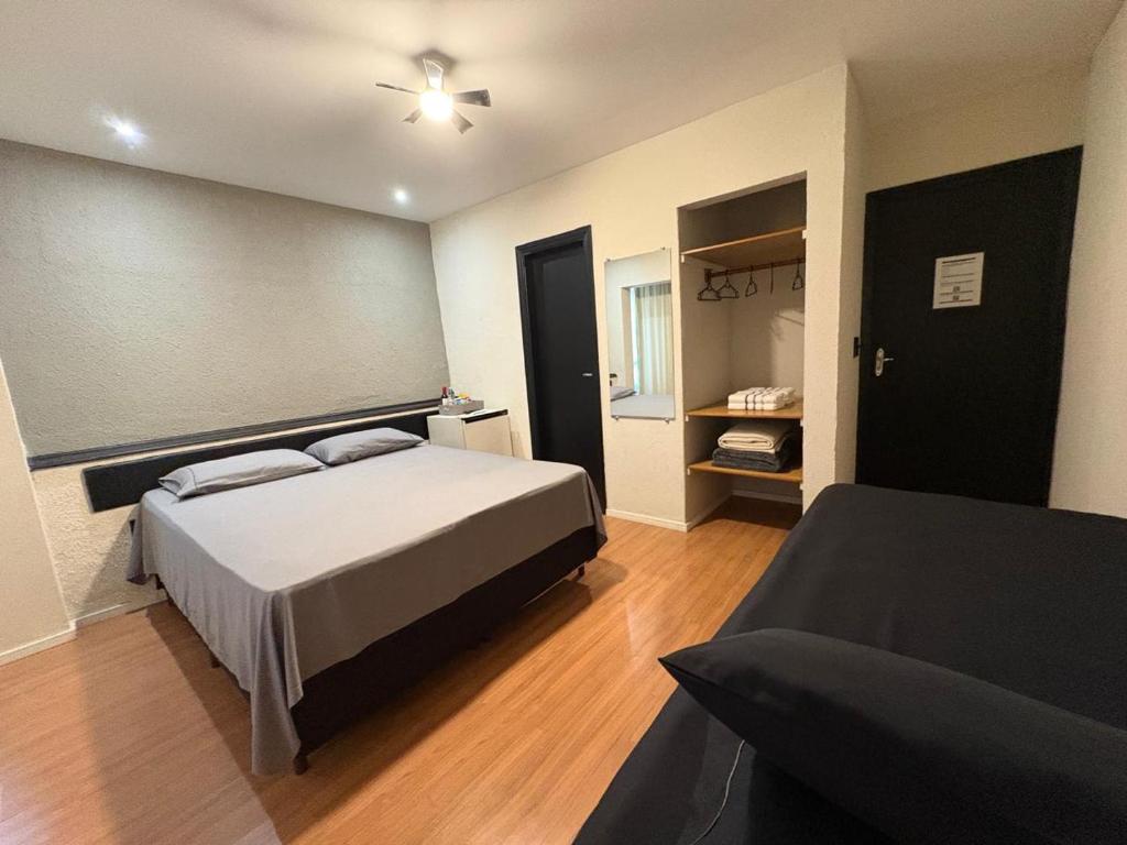 a bedroom with a bed and a couch at Travessa 12 - Suítes centro de Serra Negra - SP in Serra Negra
