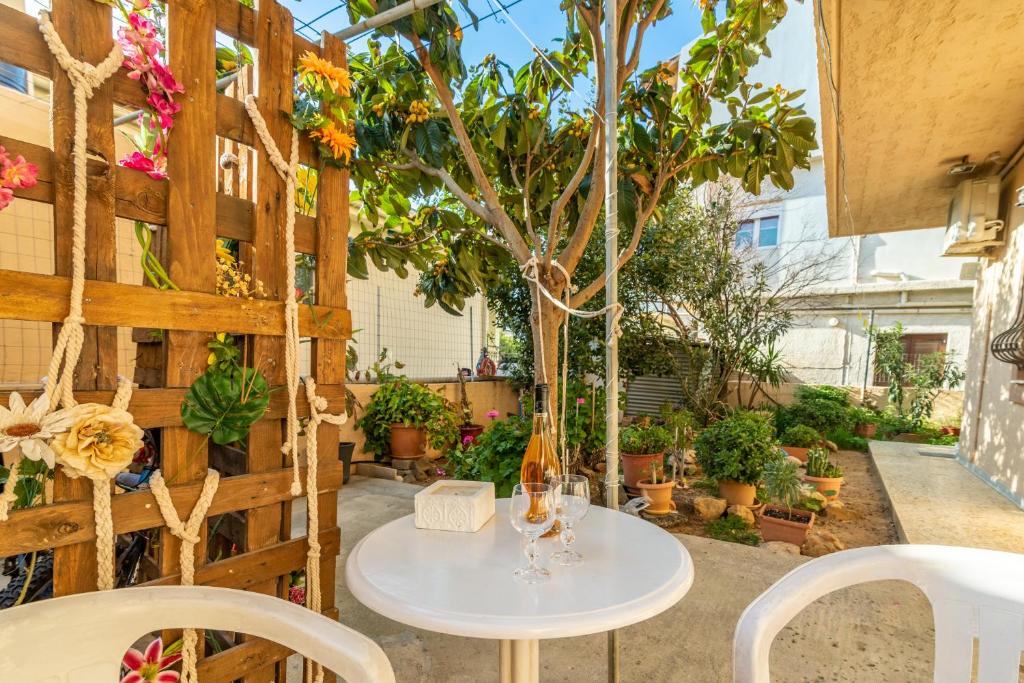 a table and chairs in a garden with a tree at Irene Studio in Amoudara Herakliou