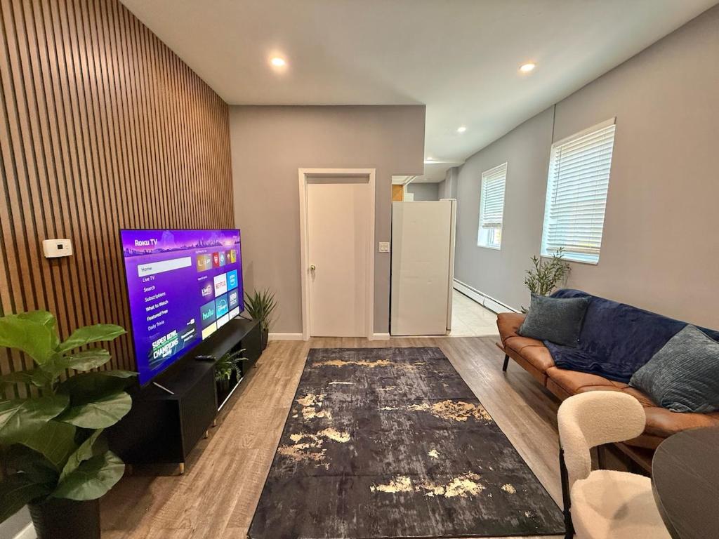 a living room with a couch and a flat screen tv at Modern apartment close to NYC in North Bergen