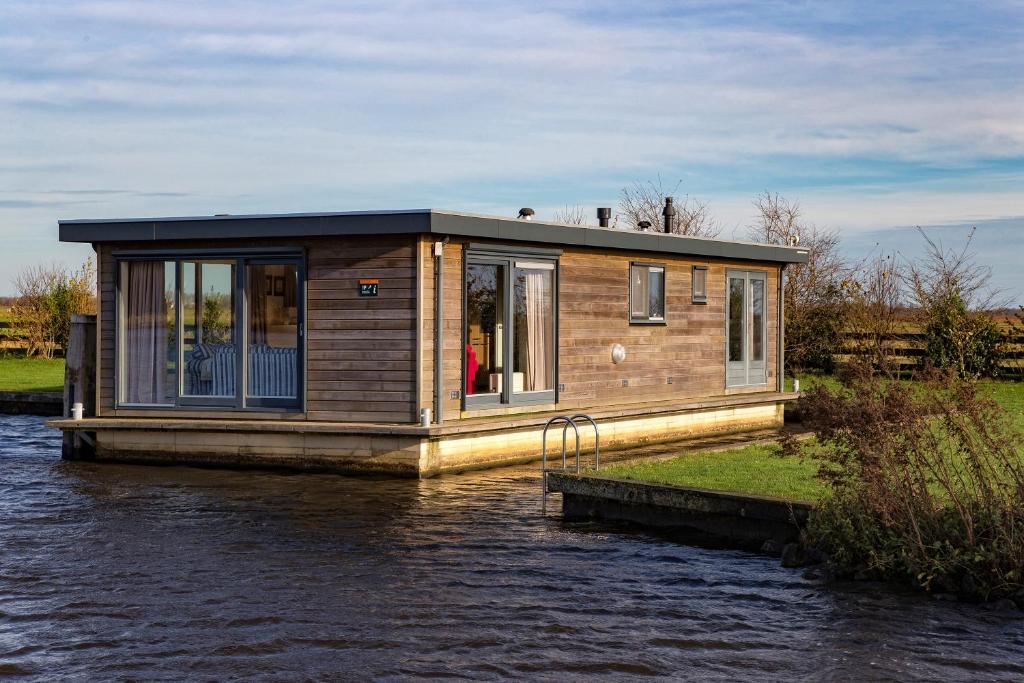 a tiny house on a boat in the water at Woonboot Sweltsje in Earnewâld