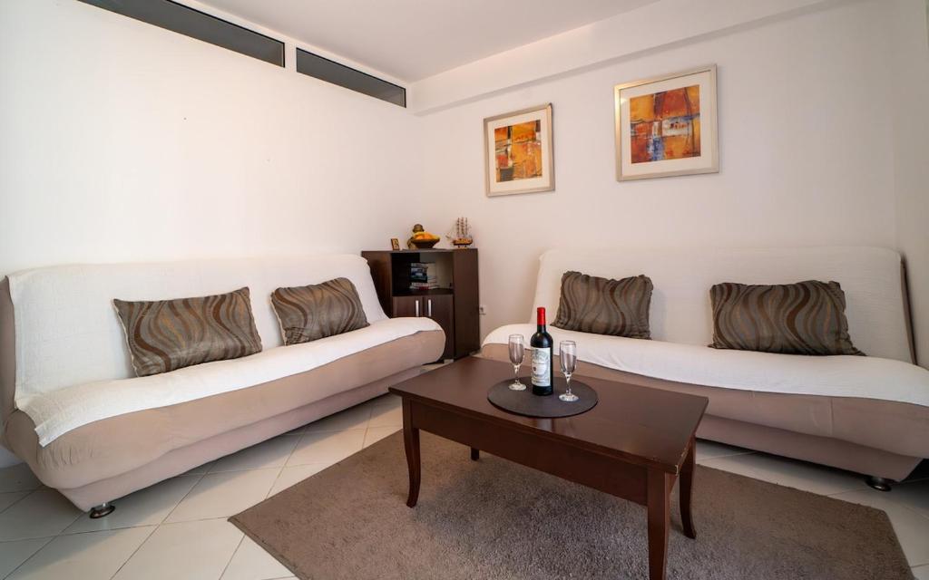 a living room with two white couches and a table at Olive View apartment in Rafailovici