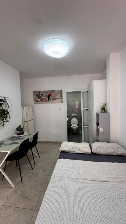 a living room with a table and a bed at Eilat Room in Eilat