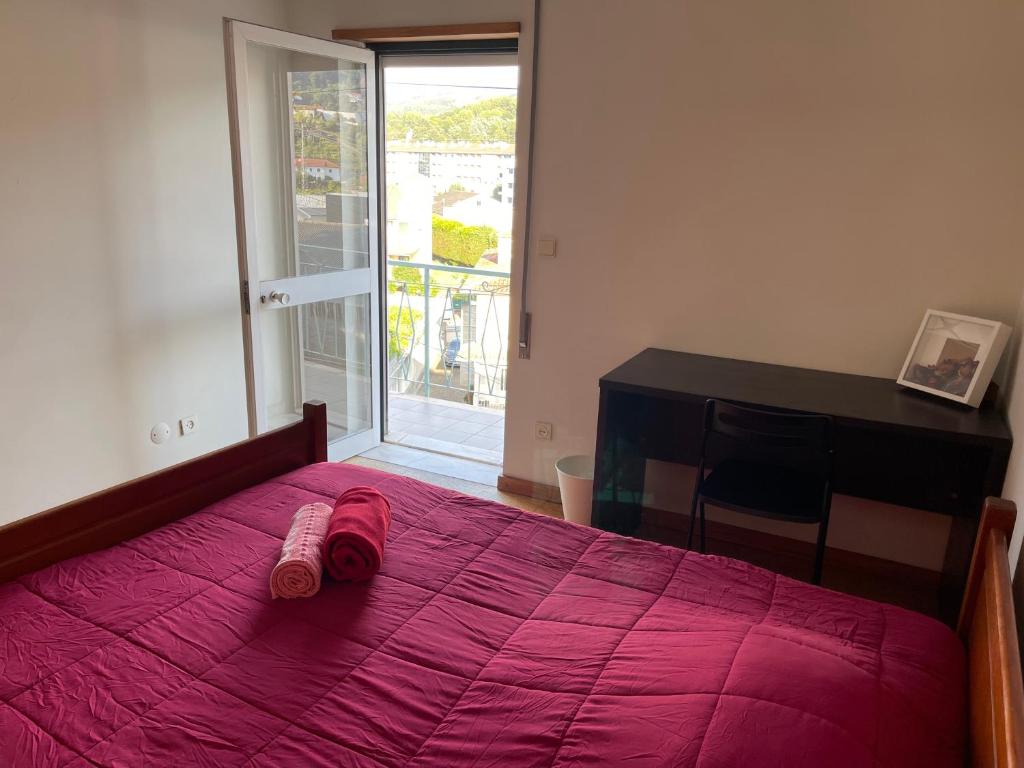 a bedroom with a bed with a pink blanket and a desk at Casa Verde in Braga