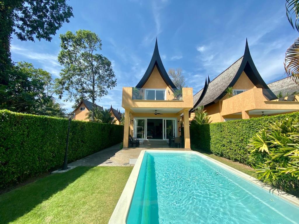 a house with a swimming pool in front of a house at Royal Shell by Utalay Koh Chang in Ban Khlong Son