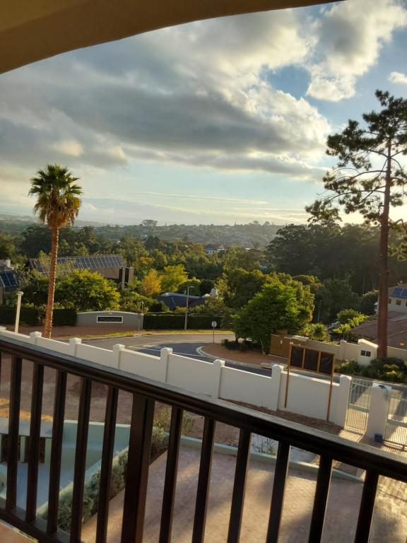 a balcony with chairs and a view of a park at Sunset View in Somerset West