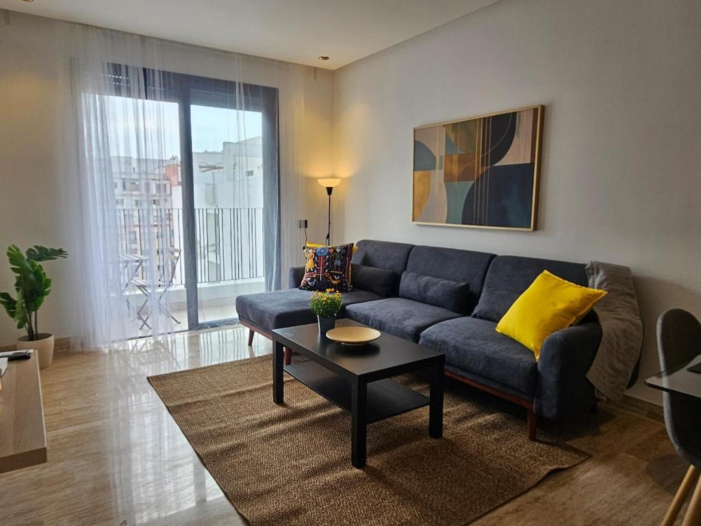 a living room with a blue couch and a coffee table at Appartement de standing - Emplacement stratégique in Casablanca