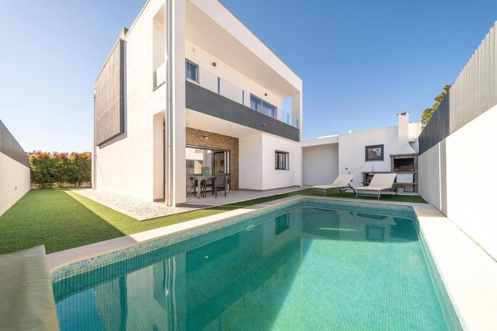 a swimming pool in the backyard of a house at GuestReady - Aroeira Pool Villa in Setúbal