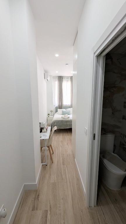 a white room with a bedroom and a bed at Lofts IFEMA CH in Madrid
