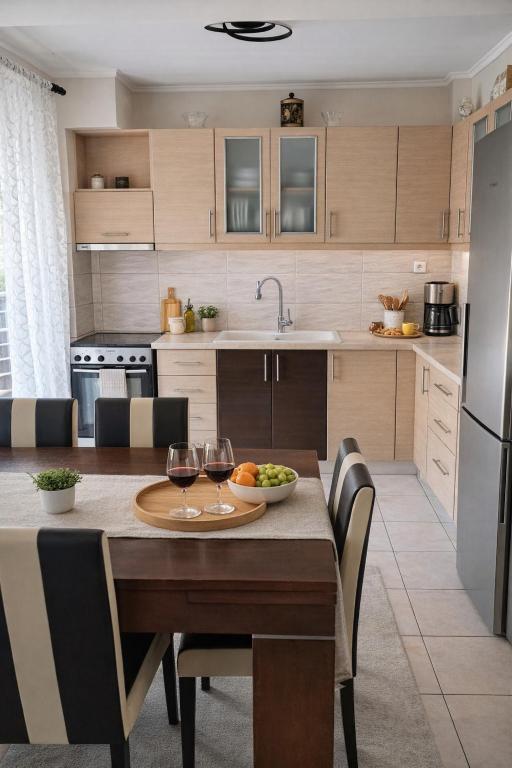 a kitchen with a table with two glasses of wine at Epanomi apartment in Epanomi