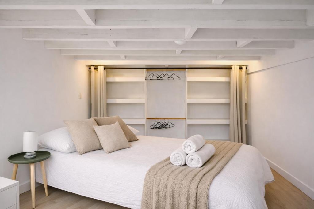 a bedroom with a white bed with towels on it at Duplex - Place du Parlement de Bretagne - Hyper Centre de Rennes in Rennes