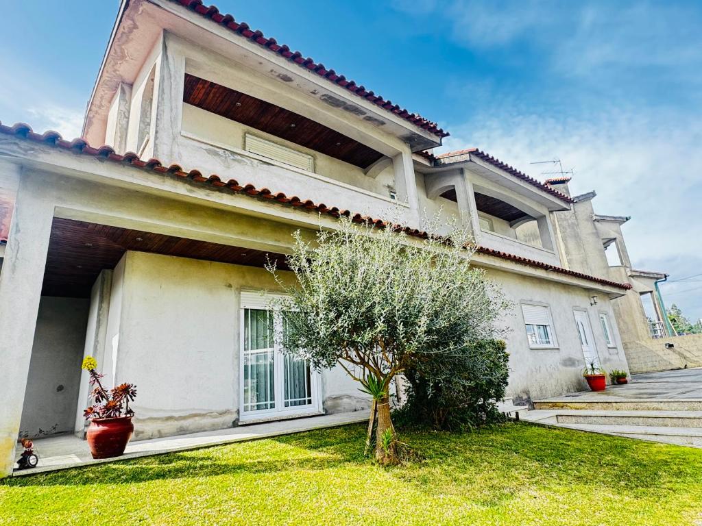 a large white house with a tree in the yard at Cantinho da Paz in Marinhas