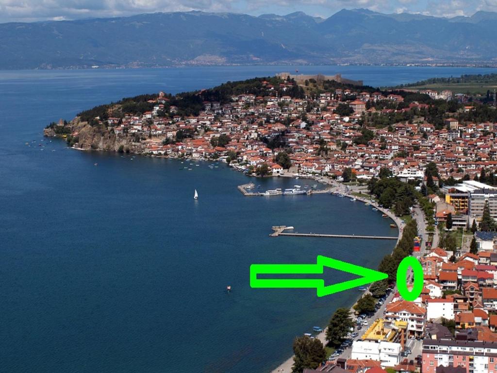 a small island in the water with a green arrow at Apartments Tomic in Ohrid
