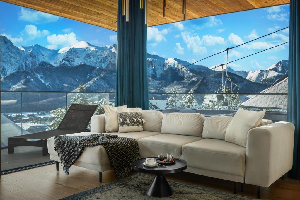 a living room with a couch and a view of mountains at Salamandra Luxury Villas with Jacuzzi by BQQK in Kościelisko