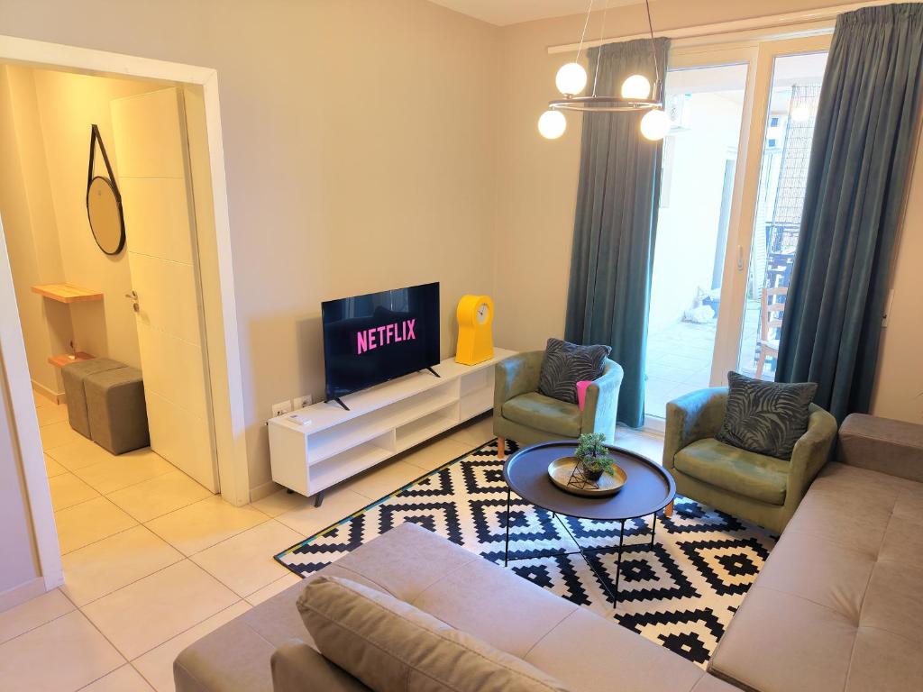 a living room with a couch and a tv at Luce Apartment in Shkodër