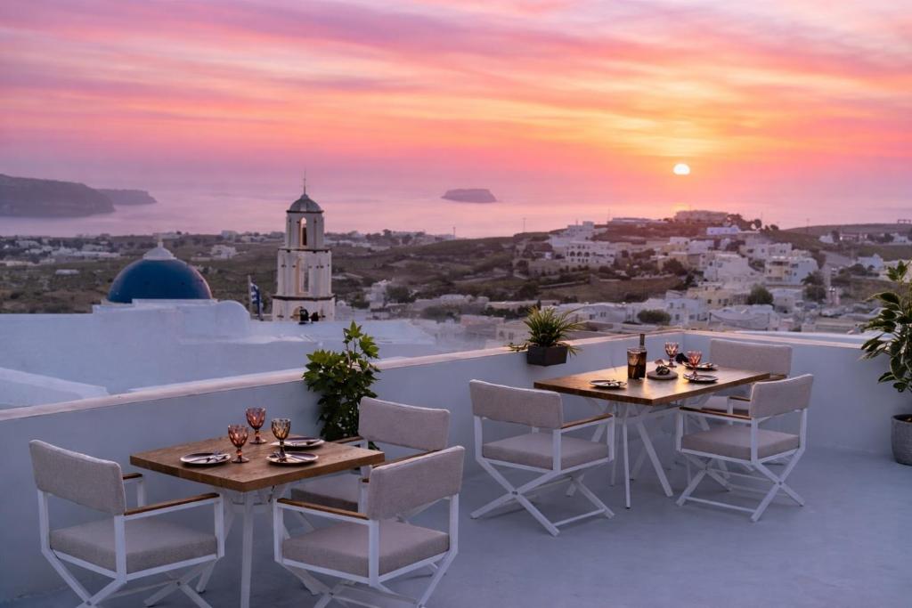 two tables and chairs on a balcony with a sunset at Sunset View Villa with Swimming Pool & Heated Jacuzzi in Pyrgos