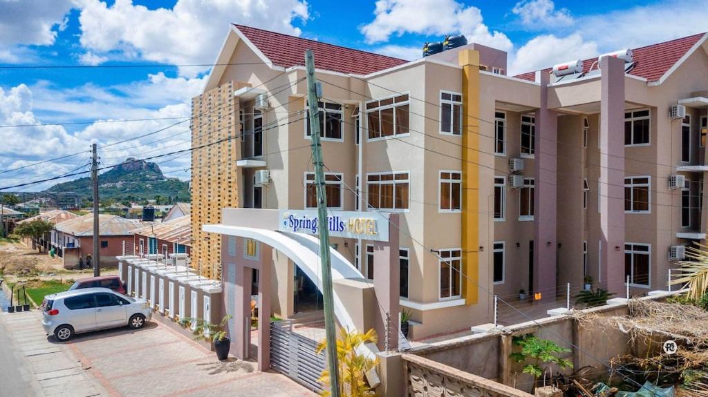a building with a car parked in front of it at Spring Hills Group in Dodoma