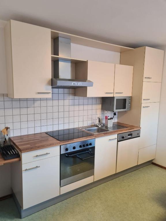 a kitchen with white cabinets and a stove top oven at Herzensplatzl in Pfaffenhofen