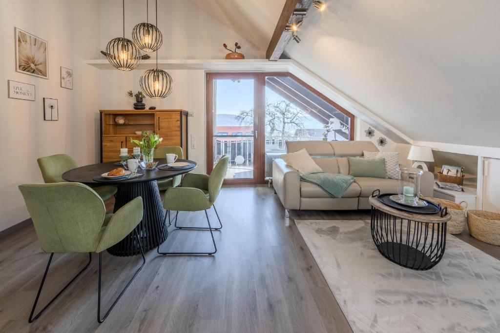 a living room with a table and chairs and a couch at Fewo Seesternchen in Öhningen