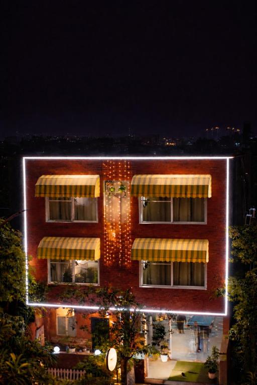 a building with lights on the side of it at night at Saffron Inn - Near India Expo Mart in Greater Noida