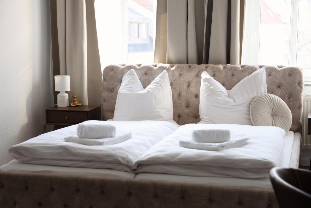 a white bed with white pillows on top of it at Boutique Suite Hannah in Bautzen