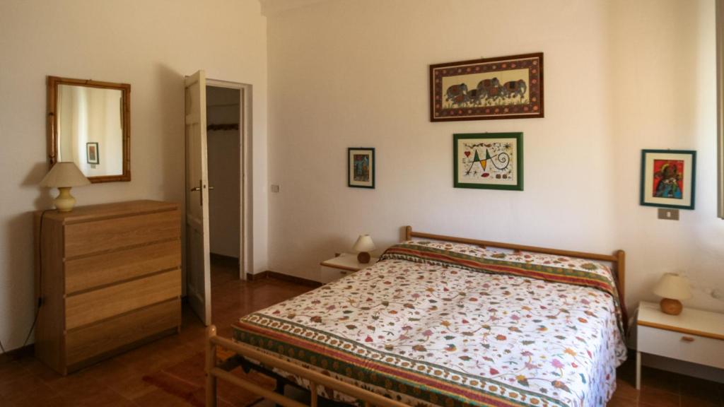 a bedroom with a bed and a dresser in it at Le Matine di San Teodoro in Stazione di Metaponto