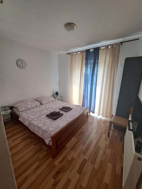 a bedroom with a bed and a wooden floor at Opatija Rooms & Apartments Semić - Free Parking and Sea View in Opatija