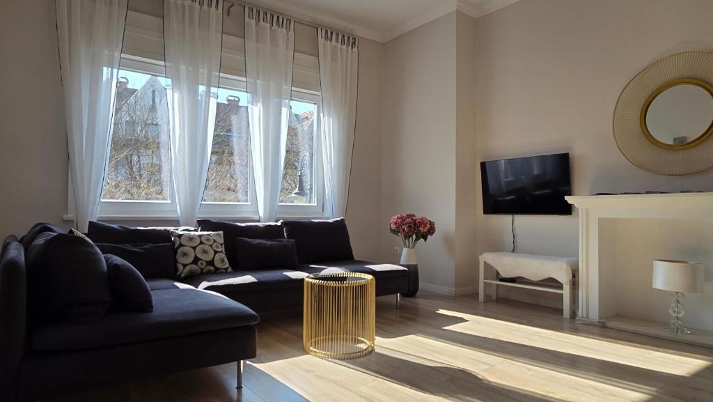 a living room with a couch and a tv at MoMa Homes Kecskemét in Kecskemét