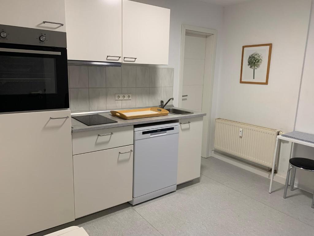 eine Küche mit weißen Schränken und einer Arbeitsplatte in der Unterkunft Ellerbach WG Komfortables Privatzimmer in Bad Kreuznach