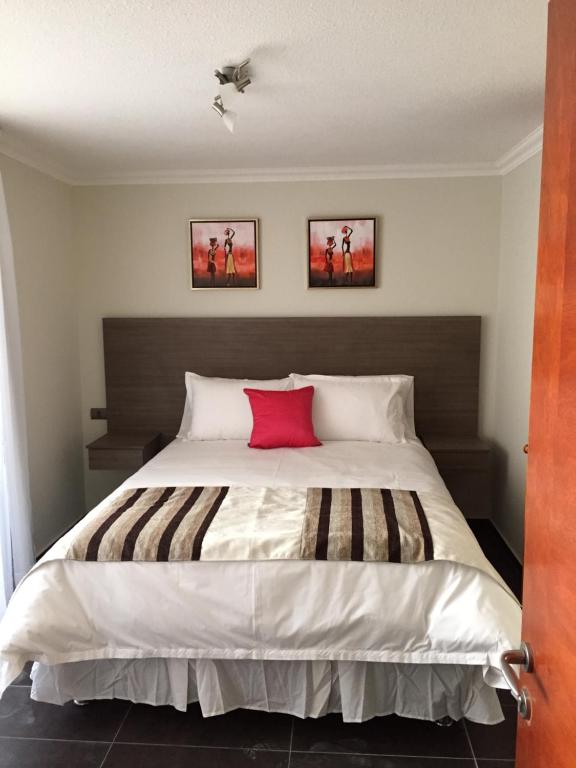 1 dormitorio con cama grande y almohada roja en Tempora Apart Hotel, en Antofagasta