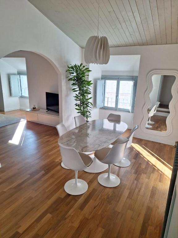 a white dining room with a table and chairs at Fontana Maggiore View Suite in Perugia