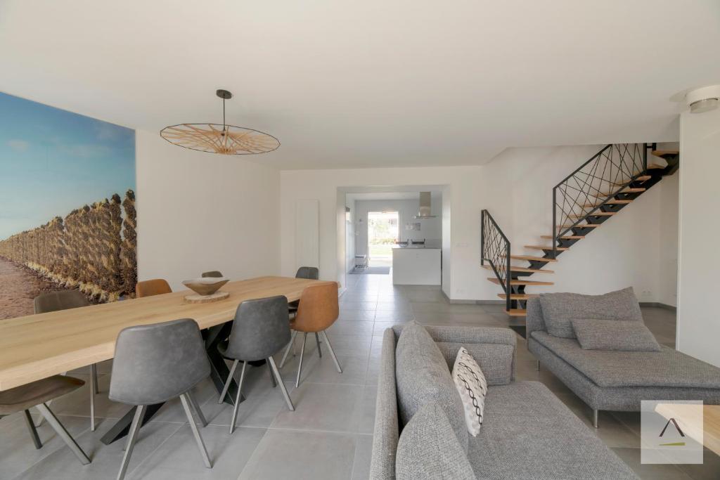 a dining room and living room with a table and chairs at Ker Lilouane in Hirel