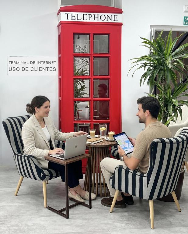 a man and woman sitting at a table with laptops at Hotel Sol Almería in Almería