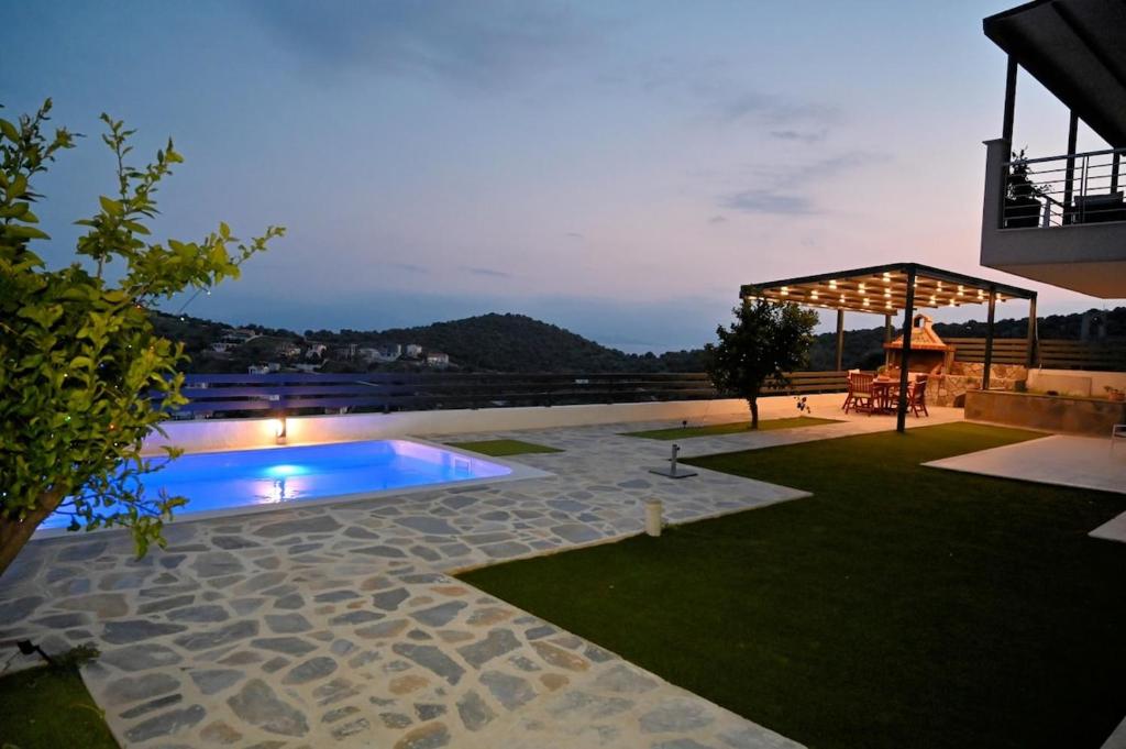a backyard with a swimming pool at night at Thea Hill in Kritharia