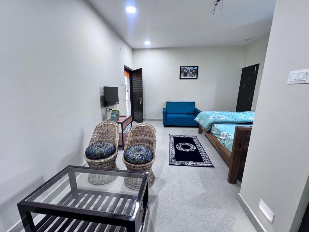 a room with two chairs and a bed in it at YNL HOMESTAY a boutique hotel in Dirang Dzong