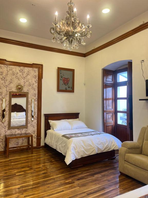 a bedroom with a bed and a chandelier at Rossa Mia Hotel Boutique in Quito